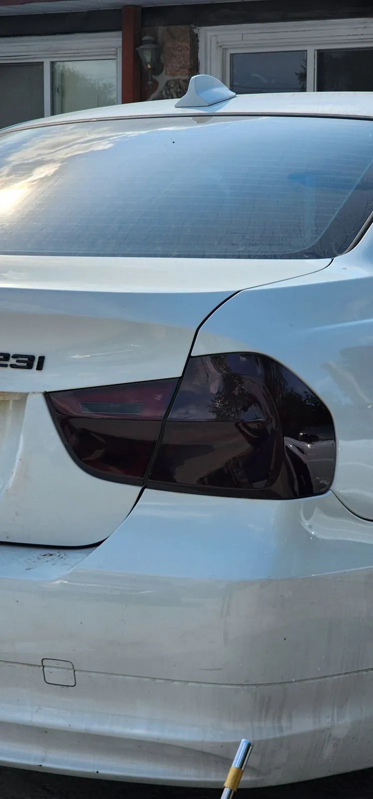 Close-up of a smoked taillight tint on a white BMW