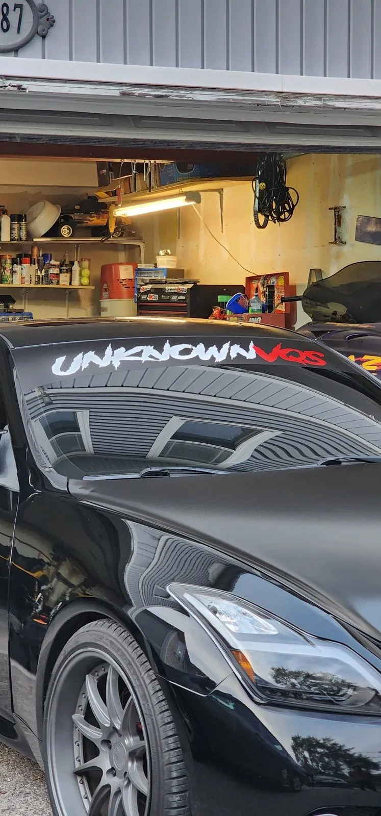 Windshield banner being fitted during an install in a garage